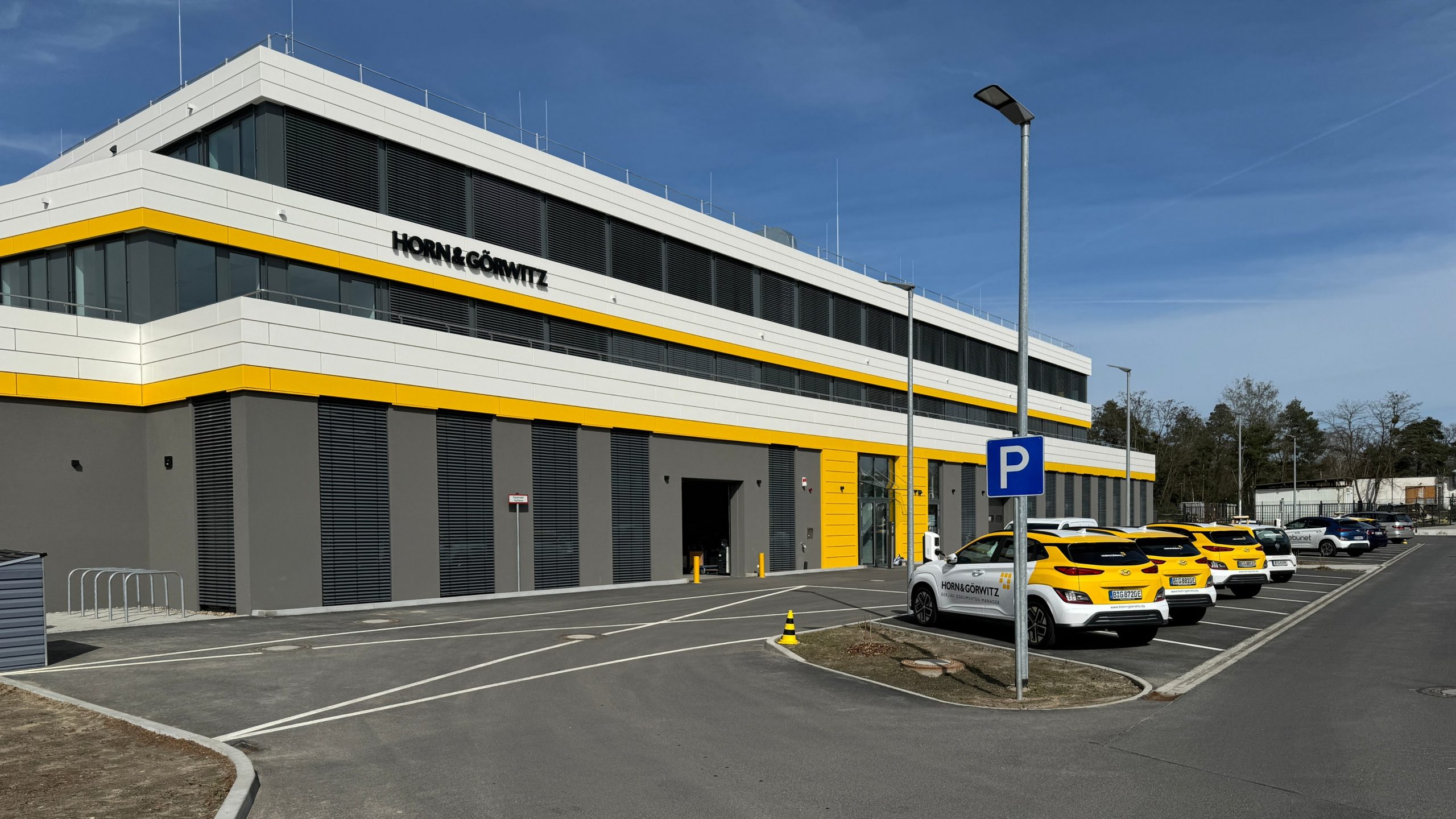 Modernes Bürogebäude von Horn & Görwitz mit gelb-weißer Fassade und angrenzendem Parkplatz