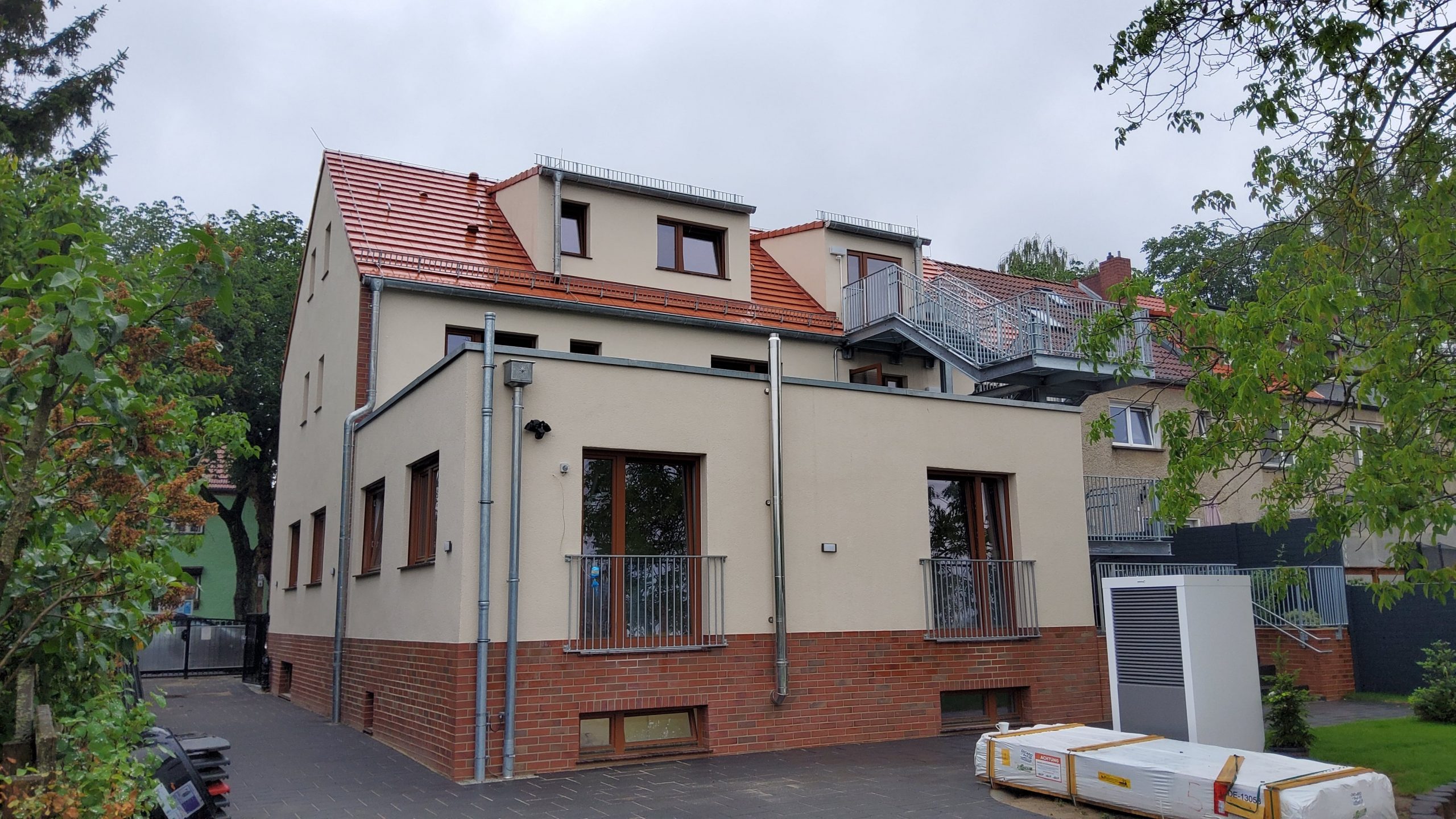 Modernisiertes Kita-Gebäude mit rotem Ziegeldach und Notausgangstreppe