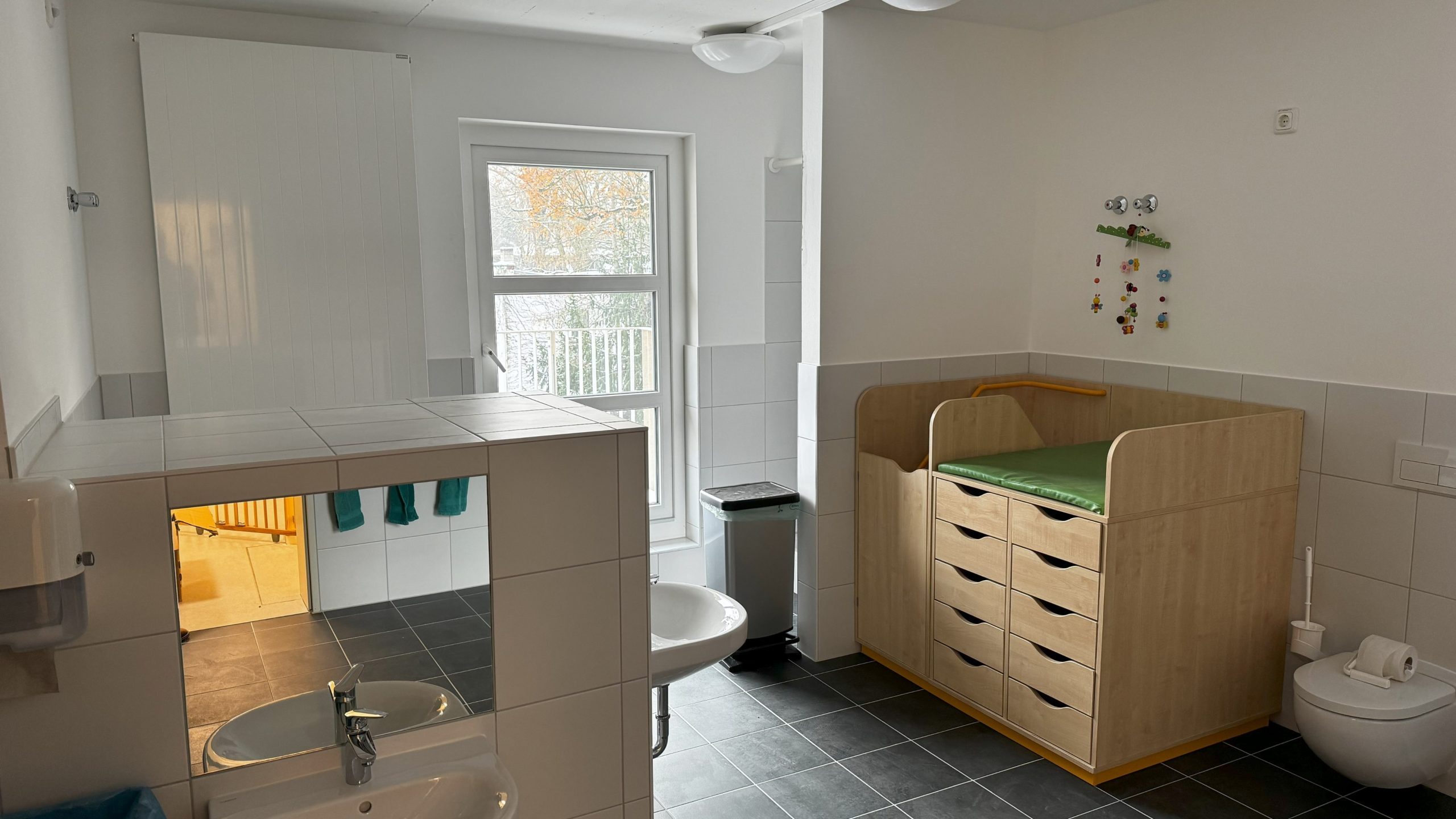 Sanitär- und Wickelbereich der Kita Villa Bunterkunt mit Wickelkommode, Kinderwaschbecken und modernen Hygieneeinrichtungen