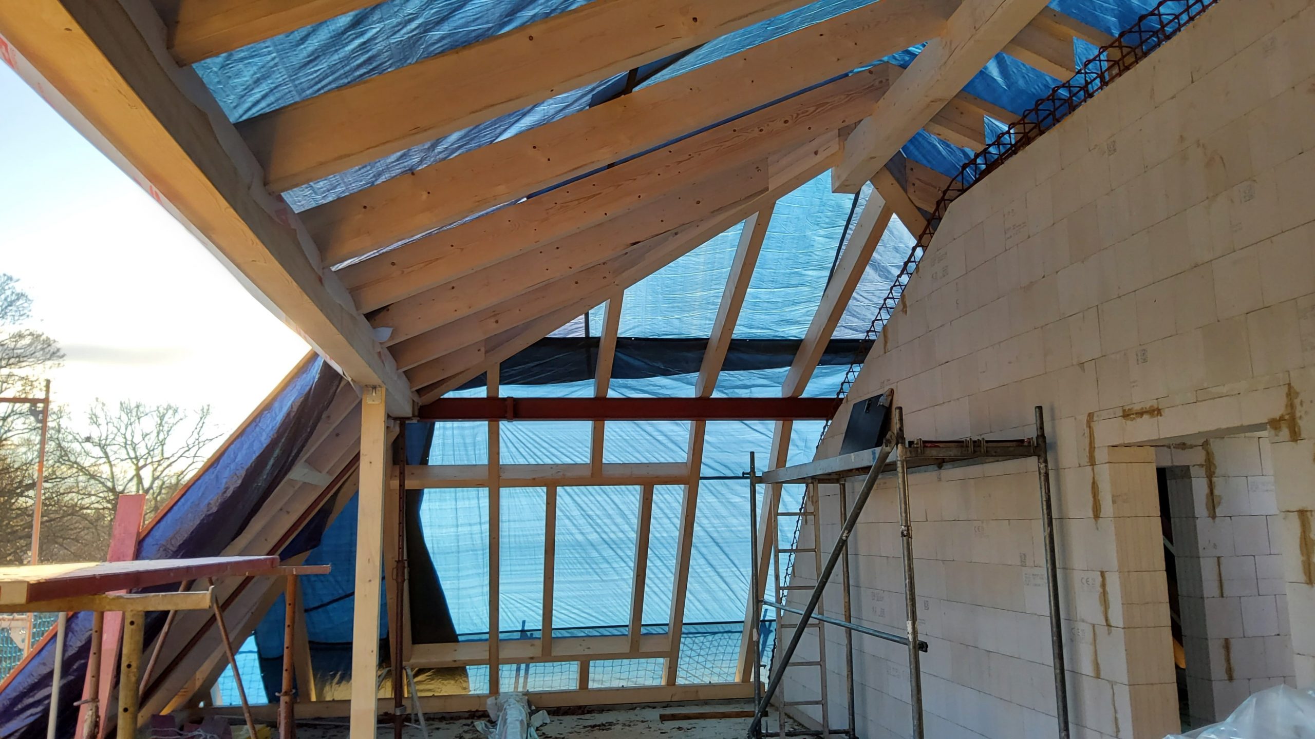 Dachrohbau mit errichtetem Holzstuhl und Folienabdeckung während der Sanierung der Kita Villa Bunterkunt – betreutes Bauprojekt